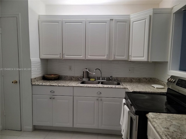 kitchen with stainless steel range with electric stovetop, white cabinetry, and sink