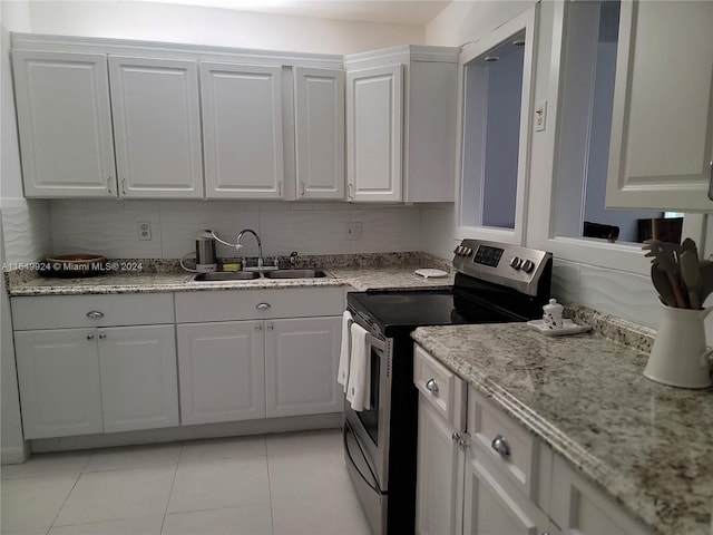 kitchen featuring light tile flooring, sink, white cabinets, and electric range