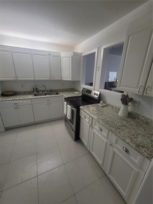 kitchen with stainless steel range with electric stovetop, white cabinets, sink, and light tile floors