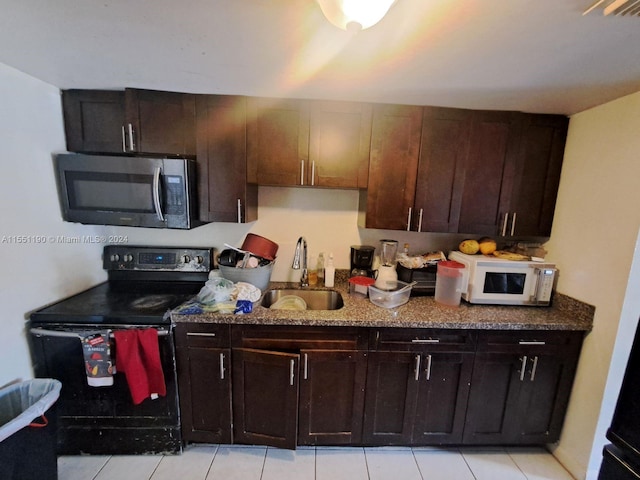 kitchen featuring black electric range, light tile patterned floors, dark brown cabinets, and sink