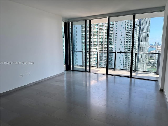 empty room with a healthy amount of sunlight and a wall of windows