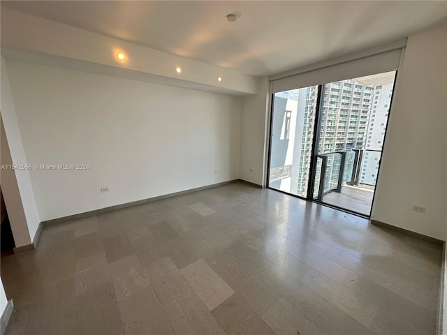 spare room with expansive windows and dark hardwood / wood-style flooring