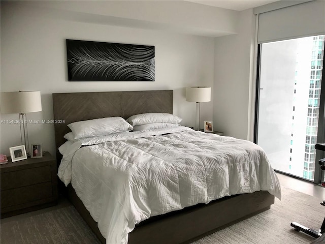 bedroom with access to outside, multiple windows, and dark hardwood / wood-style flooring