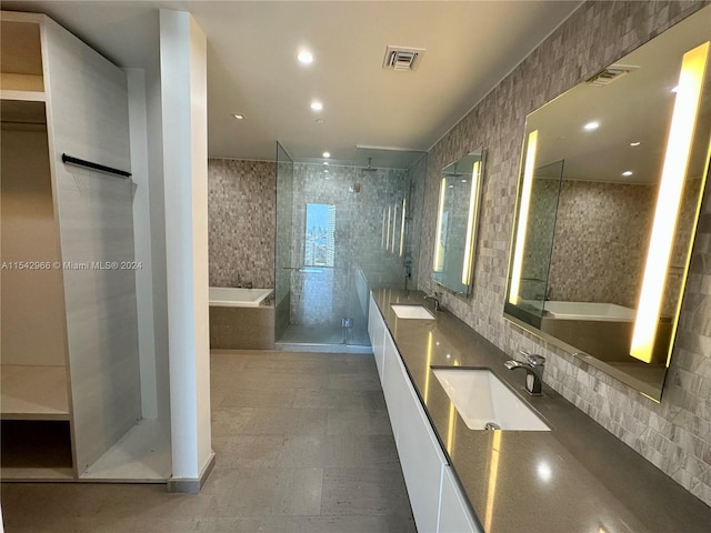 bathroom with tile walls, double vanity, tile flooring, and plus walk in shower