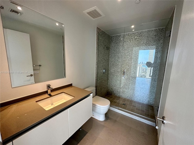 bathroom featuring toilet, vanity, and a shower with shower door