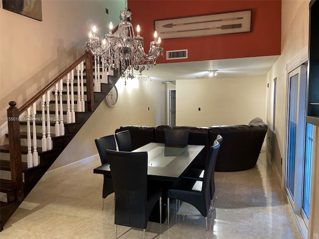 dining room with a high ceiling and a notable chandelier