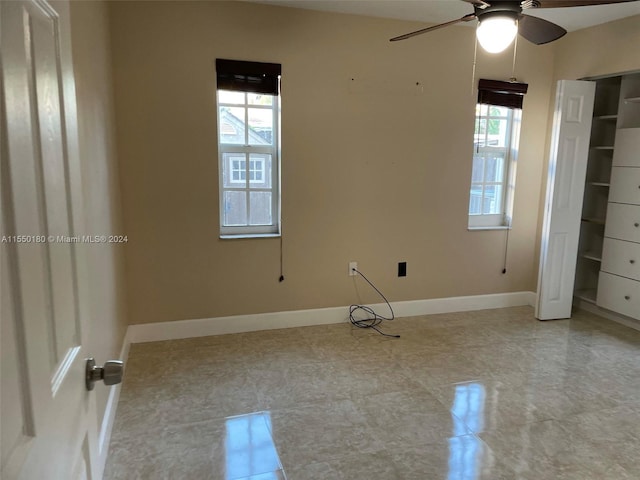 unfurnished bedroom with multiple windows and ceiling fan