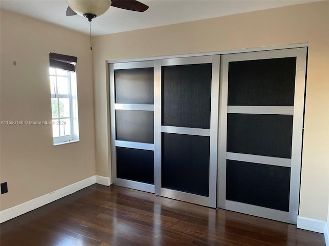 unfurnished bedroom featuring ceiling fan and dark hardwood / wood-style floors