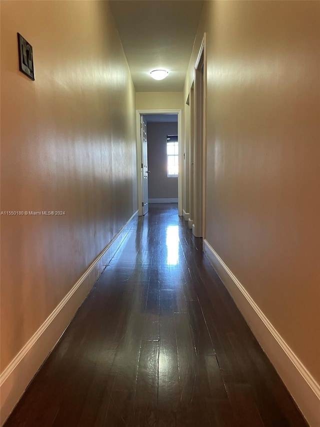 corridor with dark hardwood / wood-style flooring