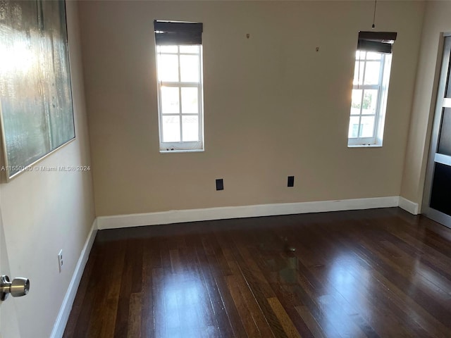 unfurnished room with dark wood-type flooring