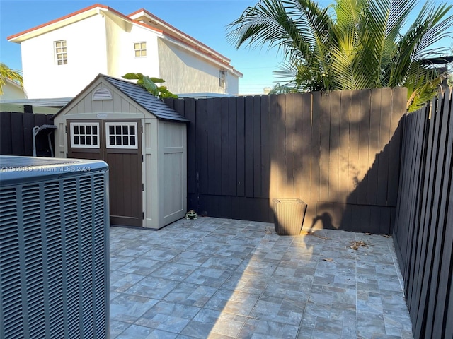 view of patio featuring a shed and central AC