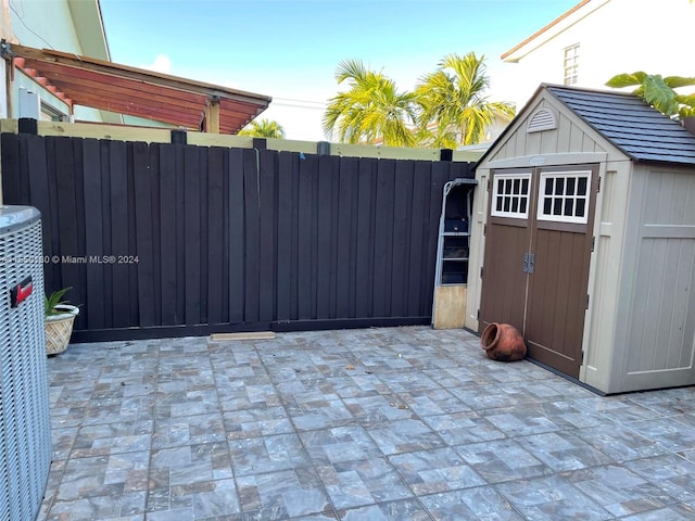 view of patio / terrace with a shed and central AC unit