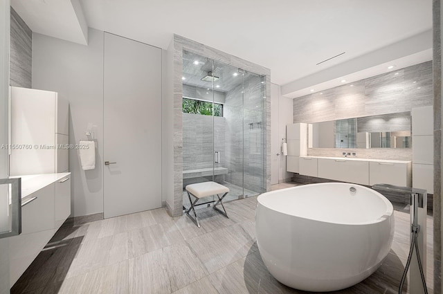 full bath with recessed lighting, a freestanding tub, a shower stall, and vanity