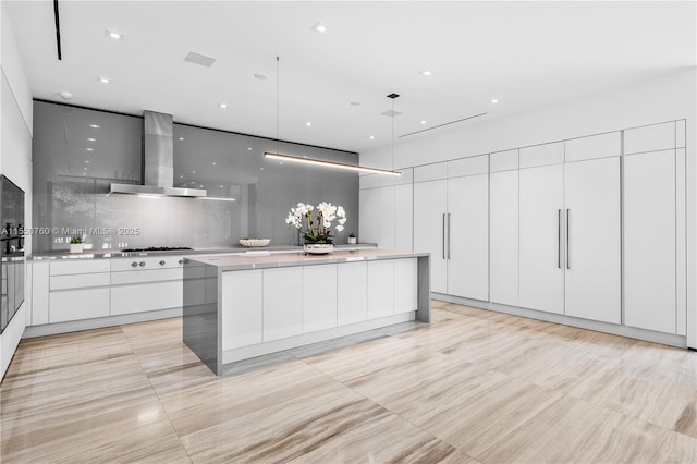 kitchen featuring white cabinets, wall chimney exhaust hood, modern cabinets, light countertops, and gas cooktop