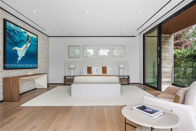 bedroom with access to exterior, expansive windows, wood finished floors, and recessed lighting