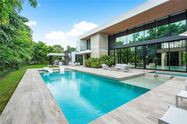 outdoor pool with stairway, a patio, and a hot tub