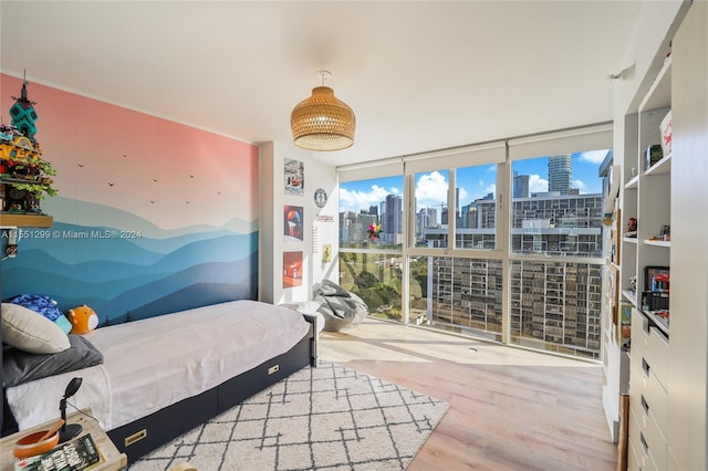 bedroom featuring floor to ceiling windows and light hardwood / wood-style flooring