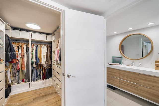 walk in closet featuring light hardwood / wood-style floors and sink