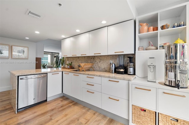 kitchen with light stone counters, white cabinetry, light hardwood / wood-style floors, dishwasher, and kitchen peninsula