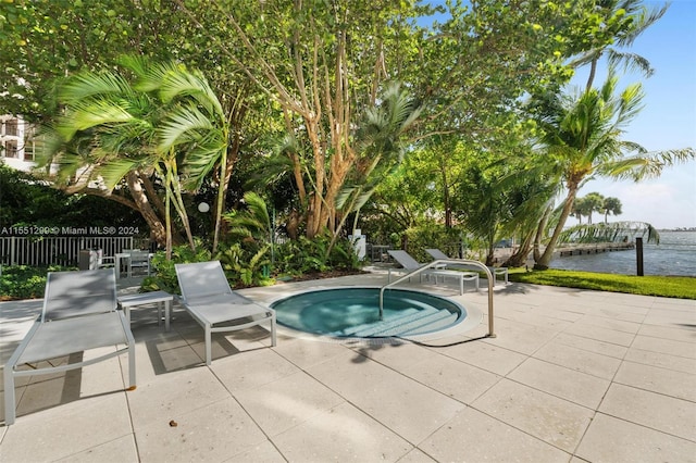 view of swimming pool featuring a water view, an in ground hot tub, and a patio area