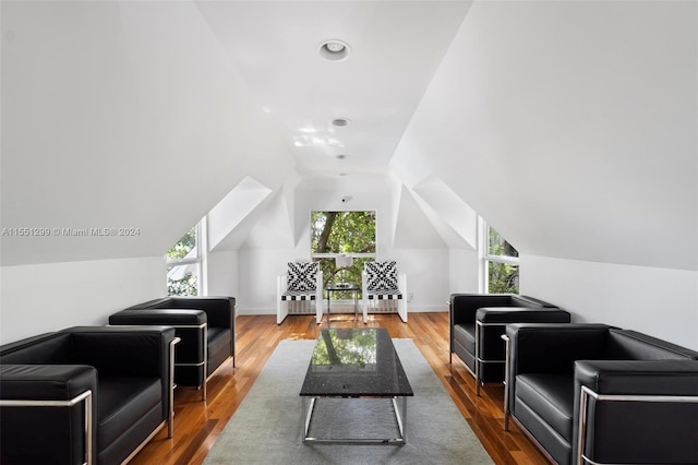 living room with a wealth of natural light, wood-type flooring, and lofted ceiling