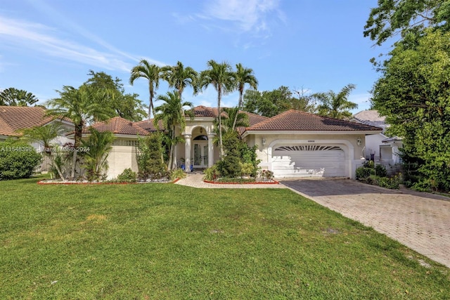 mediterranean / spanish-style house featuring a front yard and a garage