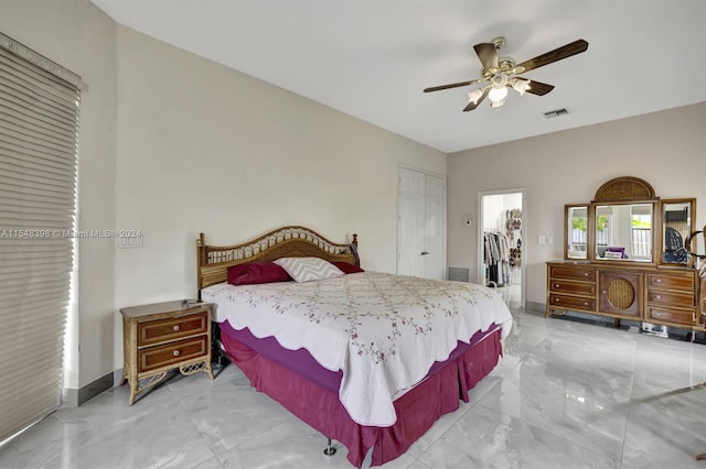 bedroom featuring light tile floors, a walk in closet, a closet, and ceiling fan