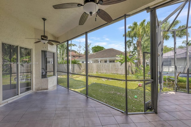 unfurnished sunroom featuring ceiling fan and vaulted ceiling