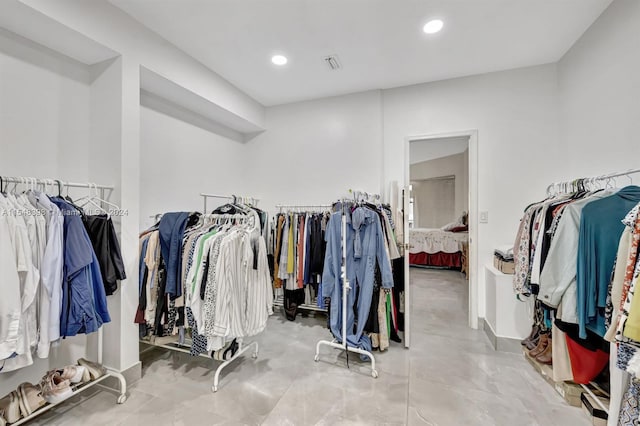 walk in closet with light tile flooring