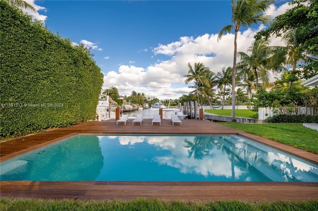 view of pool featuring a lawn and a deck