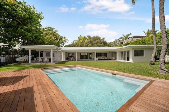 view of pool featuring a deck and a yard