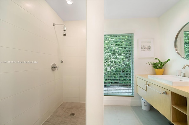 bathroom featuring tile patterned floors, tiled shower, and vanity