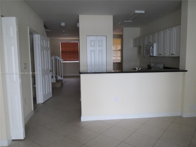 kitchen featuring light tile patterned flooring and white cabinets