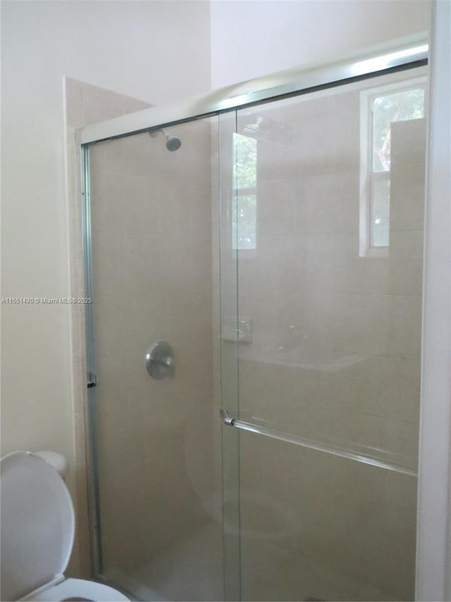 bathroom with an enclosed shower and toilet