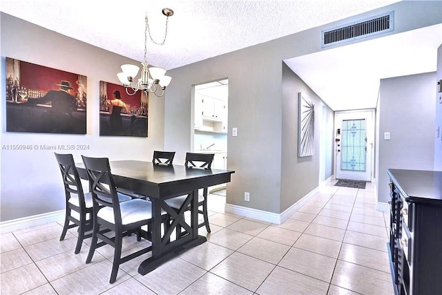 dining room with a textured ceiling, a chandelier, and light tile patterned floors