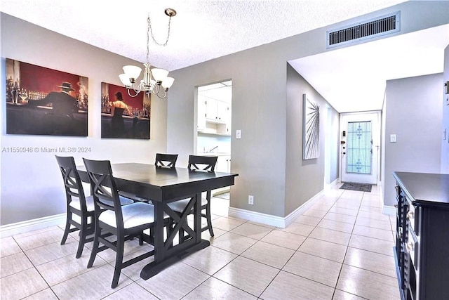 dining room featuring visible vents, a notable chandelier, light tile patterned floors, and a textured ceiling