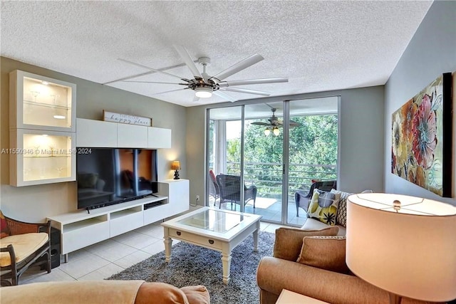 living room with ceiling fan, light tile patterned floors, and a textured ceiling