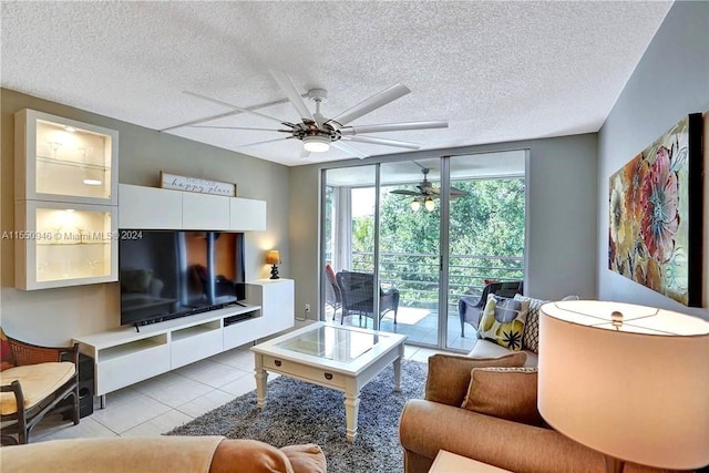 living area featuring light tile patterned floors, ceiling fan, and a textured ceiling