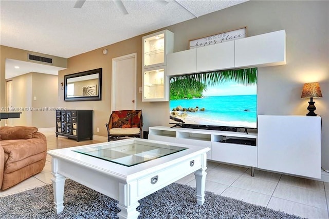 kitchen featuring visible vents, glass insert cabinets, light tile patterned floors, ceiling fan, and a textured ceiling