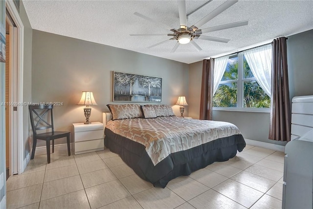 bedroom featuring a textured ceiling, baseboards, a ceiling fan, and light tile patterned flooring
