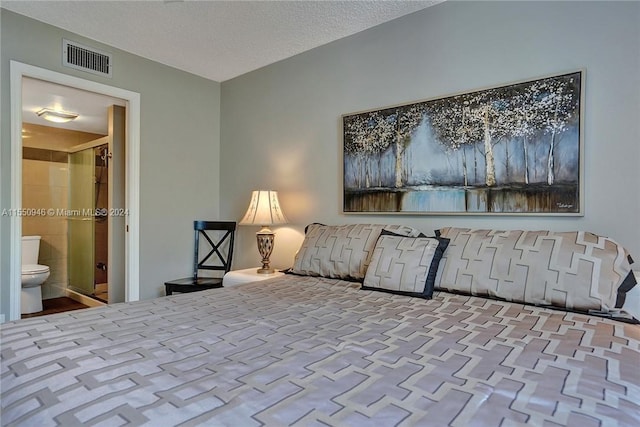 bedroom with a textured ceiling, visible vents, and connected bathroom