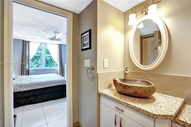 ensuite bathroom featuring vanity, tile patterned floors, ensuite bath, a textured ceiling, and ceiling fan