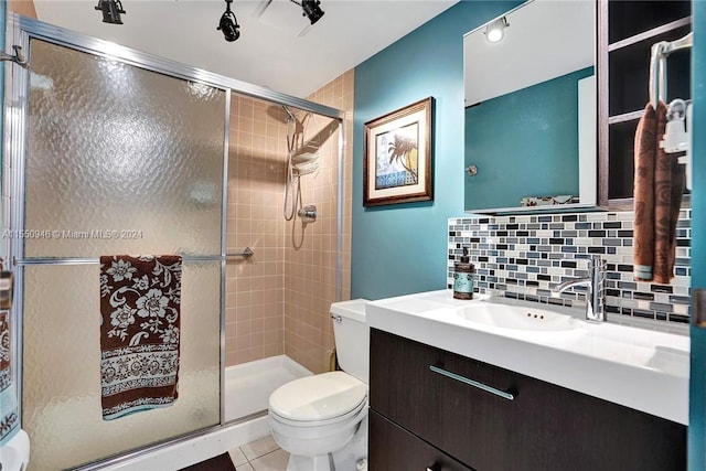 bathroom with a shower stall, vanity, tile patterned flooring, toilet, and decorative backsplash