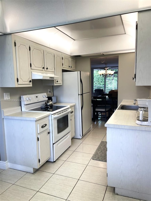 kitchen featuring an inviting chandelier, white appliances, light countertops, under cabinet range hood, and a sink