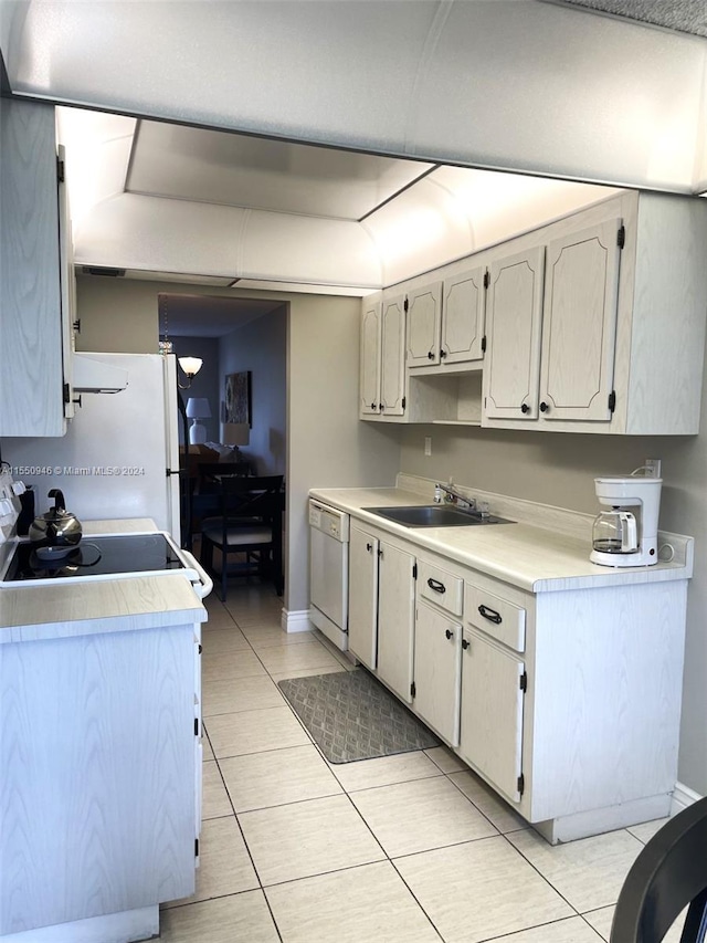 kitchen with white appliances, sink, and light tile patterned floors