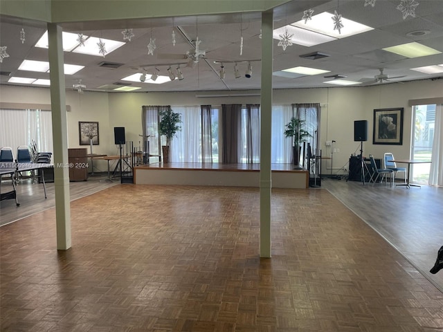 exercise room featuring ceiling fan and dark parquet flooring