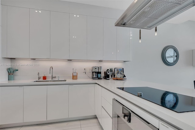 kitchen with black electric stovetop, wall oven, sink, and white cabinets