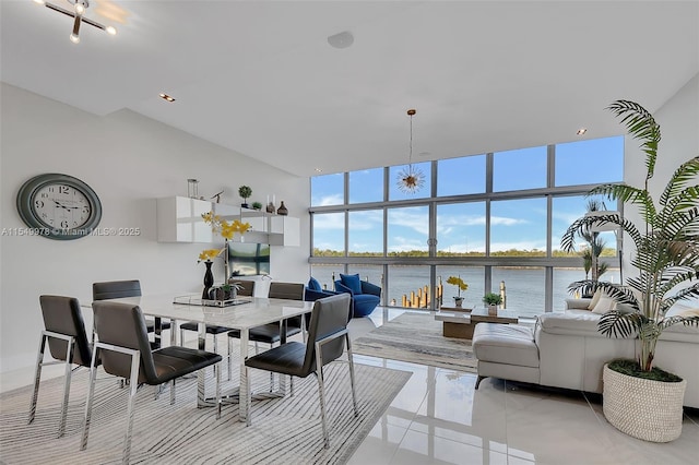 tiled dining area featuring a wall of windows, a high ceiling, and a water view