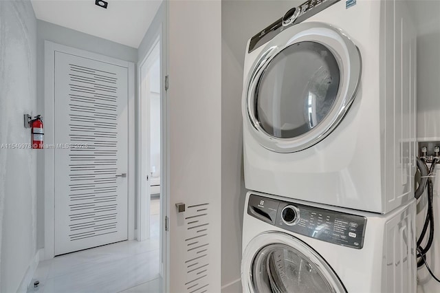 clothes washing area featuring stacked washer / dryer