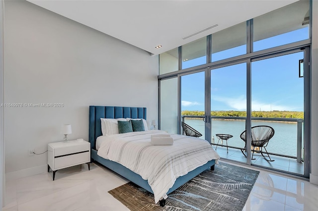 bedroom with a wall of windows and a water view